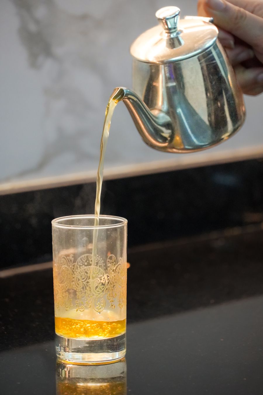 Mint tea being poured into a glass