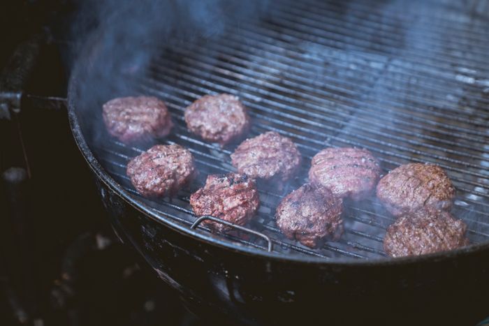 Beef patties smashed onto the grill