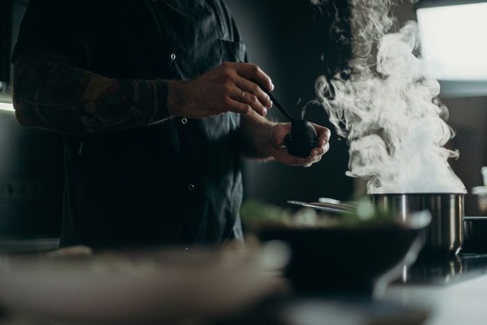 Smoke rising off the grill in a dark kitchen